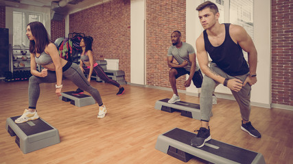 Multiracial sporty athletes working together in modern fitness club