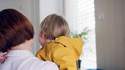 Wall Mural - Mother with small children in hall in the morning at home, sibling rivalry concept.