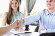 © H_Ko - Smiling man and woman shake hands as hello in office