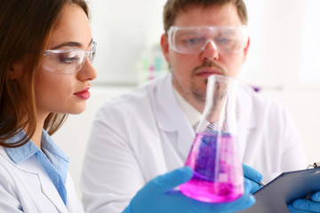 Technician hold in arms in protective gloves sample bottle