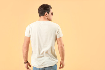 Man in stylish t-shirt on color background