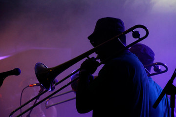 Jazz musicians performing in the French Quarter of New Orleans, Louisiana, with smoke and neon lights in the background.