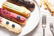 Set of different eclair cakes on wooden table
