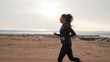 © Alexander Belinskiy - Brunette caucasian girl jogging along the road at seashore