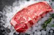 © Andrey - Raw fresh New York beef steak on ice with herbs and rosemary, close up