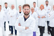 © ASDF - confident scientific leader standing in front of a team of young scientists.
