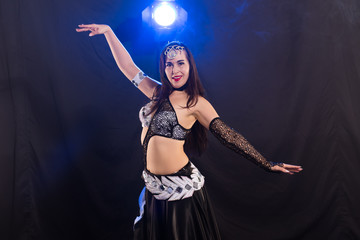 Wall Mural - Young woman dancing in Tribal Fusion style. Belly dance on the stage.