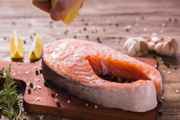 Fish Menu. Cook man plating salmon steak squeezing lemon juice. Selective Focus