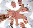 © ASDF - close up. group of different doctors putting their hands together