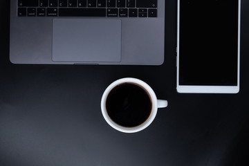 Flat lay, Office leather business table black desk, Bright Creative workspace with a black coffee, lab-top and white tablet with the sunlight, Top view with copy space