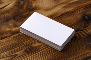 Wall Mural - Stack of white business cards on brown wooden background