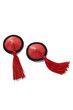 Detailed shot of two red leather nipple covers decorated with black lace ribbons and red silk tassels. The pair of pasties is isolated on the white background. 