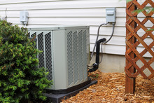 An Outdoor Air Conditioning Unit By A Home 