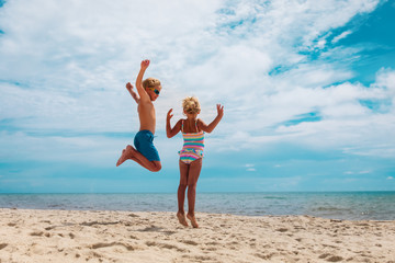 happy boy and girl enjoy beach, kids play on sea vacation