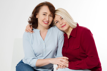 Wall Mural - Happy menopause concept. Two healthy and beautiful middle aged women isolated on white background. Woman support woman. Closeup faces and skincare makeup.