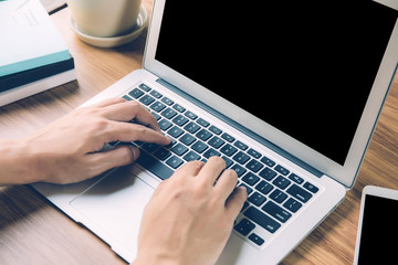 Wall Mural - hand man working laptop computer with blank screen, work from home for social distracting is new nor