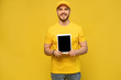 © opolja - Cool delivery man with tablet. demonstrates tablet. looking at camera. isolated on yellow background.