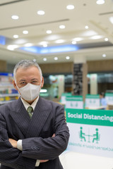 Poster - Mature Japanese businessman with mask social distancing at the food court