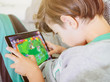 © oz - child with tablet in wrong posture playing addictive video game