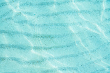 Wall Mural -  Blue sea ocean, water sun reflection, and sand background. Top view