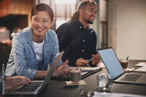 Fotomural Diverse businesspeople smiling while working with colleagues in