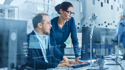 Aufkleber - Modern Electronics Factory: Female Supervisor Talks to a Male Electrical Engineer who Works on Computer with CAD Software. Developing PCB, Microchips, Semiconductors and Telecommunications Equipment