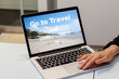 © Metro Hopper - GO TO TRAVEL キャンペーン　　Go Toキャンペーン旅行のオンライン予約検索のイメージ　ノートパソコンで旅行の予約検索の画面を見せている女性の手