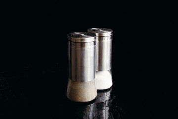 Salt and pepper shaker on black background