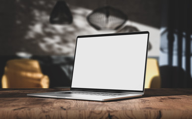 Wall Mural - laptop blank screen on wooden table in vintage living room interior, angled view