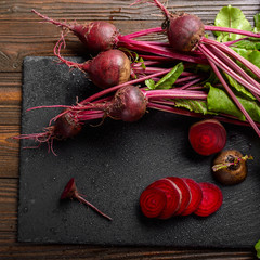 Wall Mural - Top view at fresh organic beets with leaves on wooden rustic table close up view