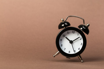 black vintage alarm clock falling to the floor with a colored background