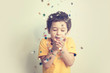 happy birthday child. Photo of charming cute fascinating nice little boy blowing confetti at you to show her festive mood with emotional face expression.