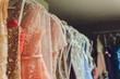 Many ladies evening gown long dresses on hanger in the dress rent shop for the wedding day. Dresses rental concept. Wedding dress for the wedding.selective focus.Ball gown rental concept.