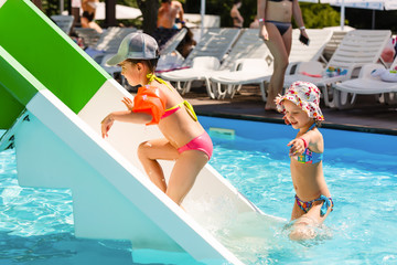 Wall Mural - two little girls playing in the pool