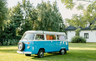 Blue classic retro vehicle parked near hangar. Classic Blue van with sunlight