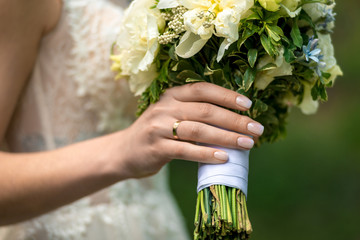 Wall Mural - Beautiful wedding bouquet in the hand of the bride close-up