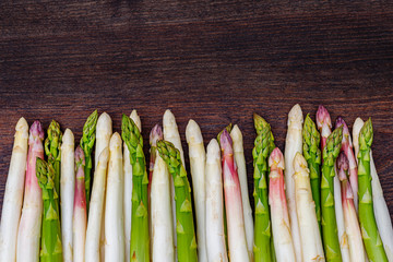 White and green fresh asparagus on the table, close up. Different varieties of German row green and white asparagus on the table.