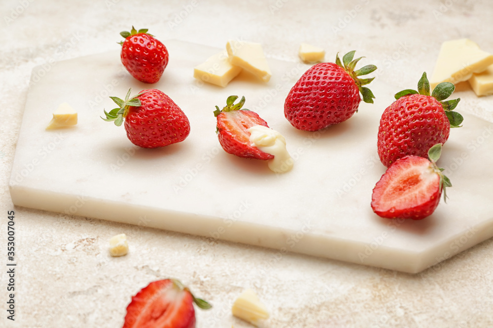 Board with tasty strawberry and melted chocolate on light background