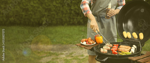 Man having picnic and cooking food on barbecue grill outdoors, closeup with space for text. Banner design