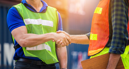 Wall Mural - Close up of engineer and foreman worker handshake with blurred construction site, Success and Teamwork concept