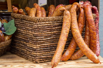 Freshly prepared smoked sausage in basket on stall