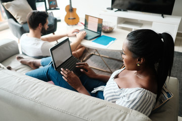 Couple Working And Playing With Laptop Computer At Home