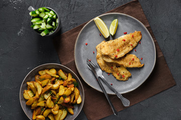 Fried breaded hake fillet with spice and roasted potato wedges