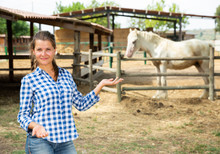 Successful Woman Farmer Near Enclosure With Horses