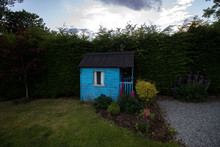 A Blue Garden Shed With Colorful Flowers And Green Grass In Scotland