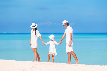 Wall Mural - Happy family of three having fun together on the beach