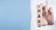 © andranik123 - Man showing HR word on wooden cubes.