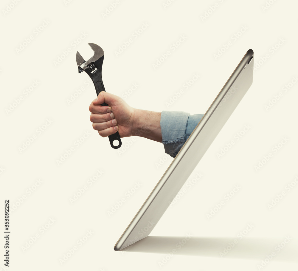 The human hand with  black wrench stick out of a digital tablet screen. Concept of technical support. - obrazy, fototapety, plakaty 