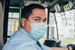 young hispanic bus driver wears blue mask