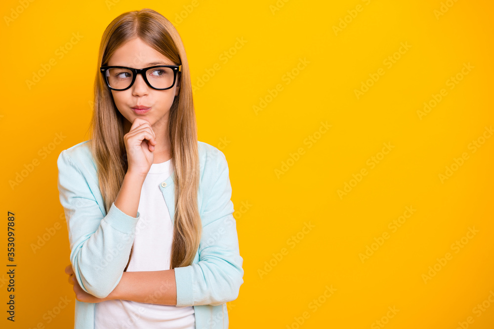 Photo of beautiful little lady hold arm on chin diligent student pupil school girl look side empty space tricky person wear specs casual shirt isolated yellow bright color background - obrazy, fototapety, plakaty 